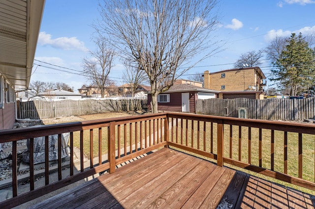 wooden terrace with a fenced backyard, a lawn, and an outdoor structure