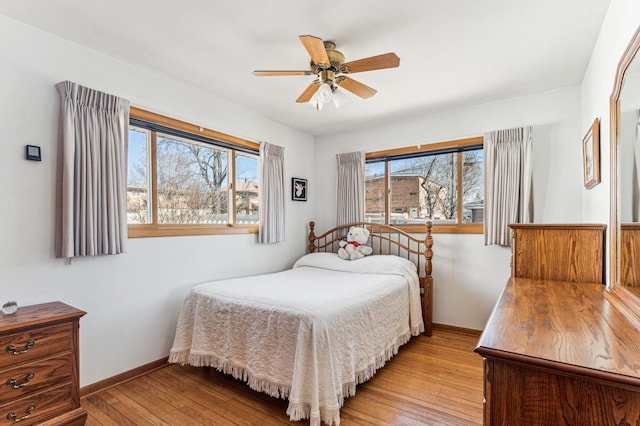 bedroom with ceiling fan, light wood-type flooring, and baseboards