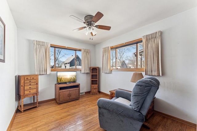 sitting room with ceiling fan, light wood-style flooring, and baseboards