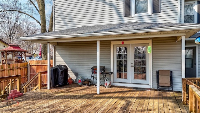 wooden deck featuring fence, grilling area, and french doors