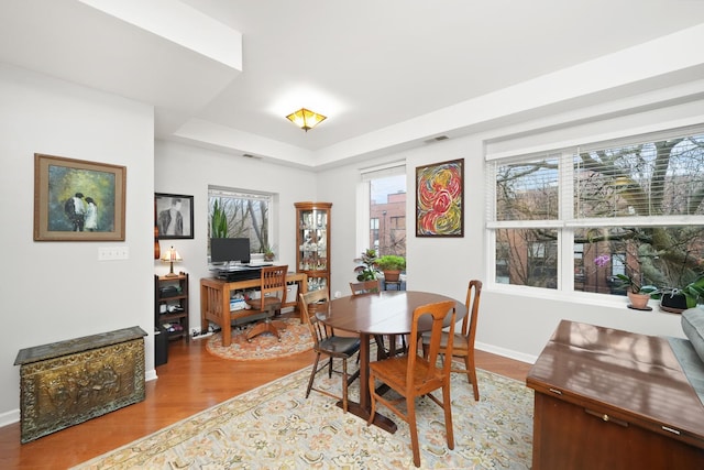 dining space featuring visible vents, plenty of natural light, baseboards, and wood finished floors