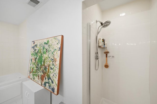 bathroom featuring a tub, tiled shower, and visible vents