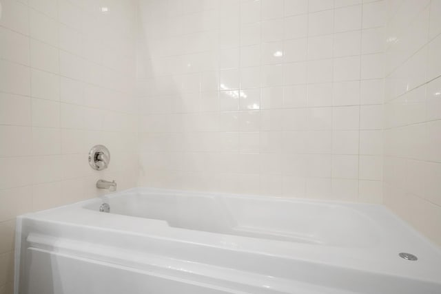 bathroom featuring a bathing tub and tile walls