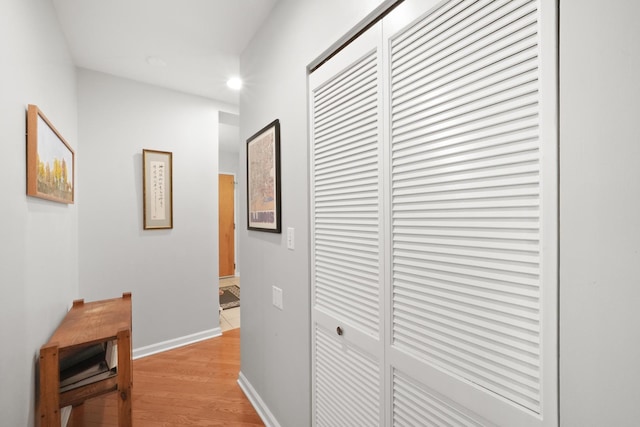 hall with light wood finished floors, baseboards, and recessed lighting