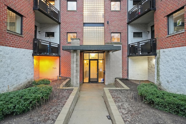 doorway to property featuring brick siding