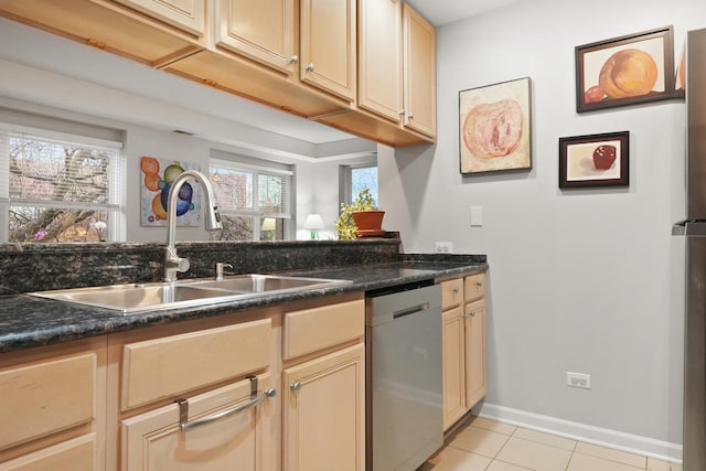 kitchen featuring light tile patterned floors, stainless steel dishwasher, a sink, and baseboards