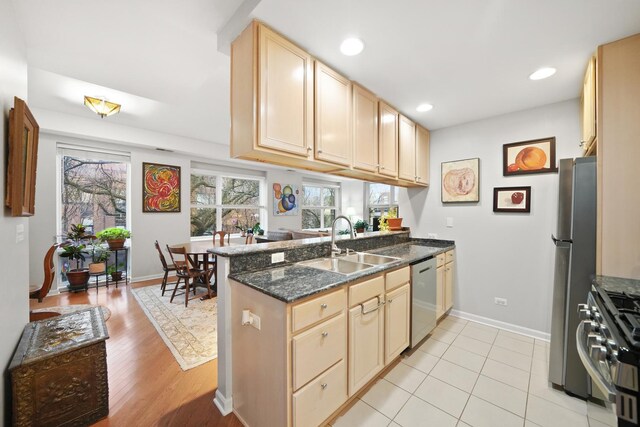 kitchen with recessed lighting, appliances with stainless steel finishes, a sink, a peninsula, and baseboards