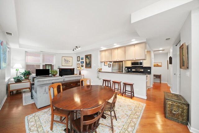 dining area featuring baseboards, light wood-type flooring, visible vents, and recessed lighting