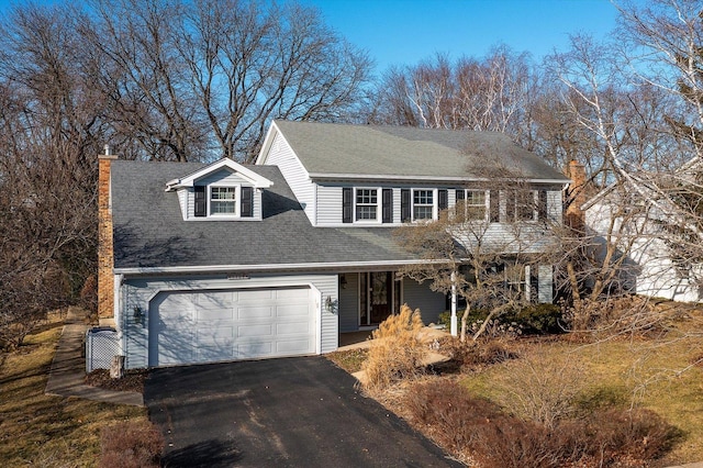 view of front facade featuring a garage, driveway, and a chimney