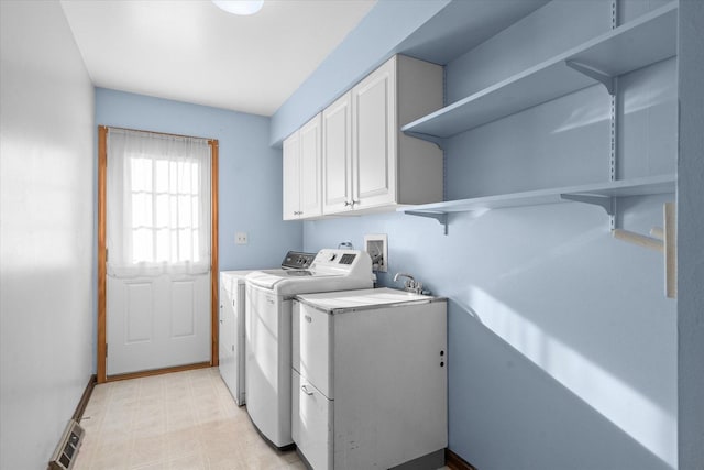 laundry area featuring visible vents, light floors, washer and dryer, cabinet space, and a sink