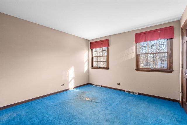 empty room with visible vents, carpet floors, and baseboards