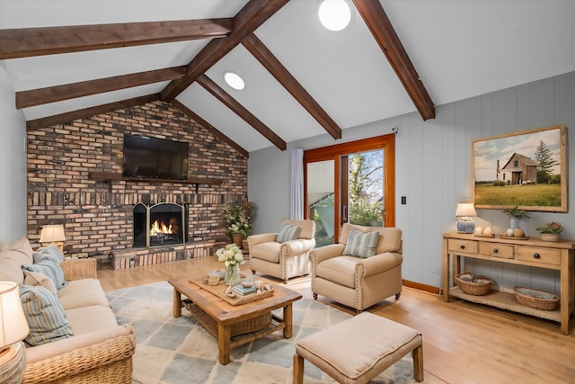 living room with wood finished floors, vaulted ceiling with beams, a fireplace, and brick wall