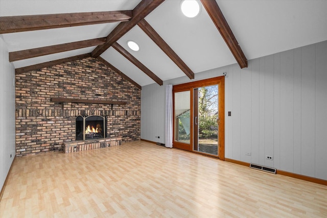 unfurnished living room featuring visible vents, a brick fireplace, lofted ceiling with beams, and wood finished floors