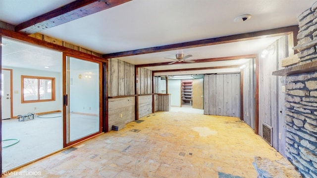 unfurnished room with visible vents, beamed ceiling, and stairs