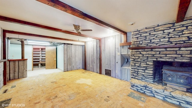 unfurnished living room featuring visible vents, beam ceiling, and a ceiling fan