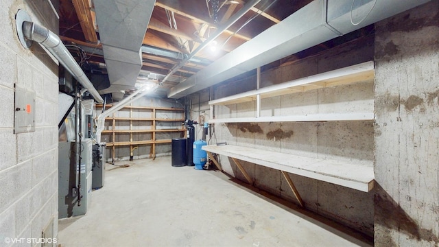 unfinished basement featuring heating unit and electric panel