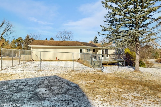 rear view of house featuring a deck and fence