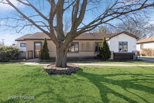 view of front of home with brick siding and a front lawn