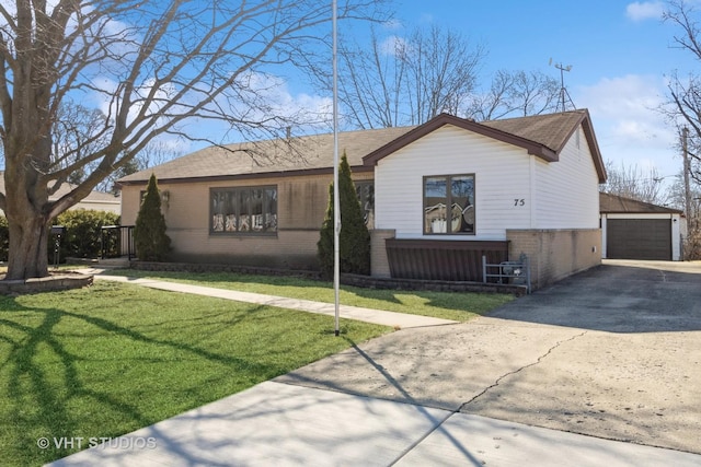 single story home with brick siding, a detached garage, an outbuilding, and a front lawn