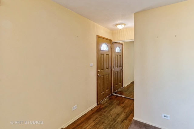 foyer featuring baseboards and dark wood-style flooring