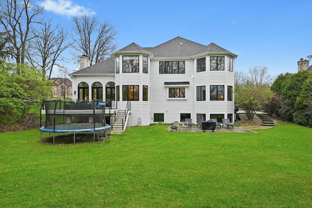 11735 Orchard St, Willow Springs, IL 60480 - back of property with a chimney, a trampoline, a patio area, stairway, and a yard