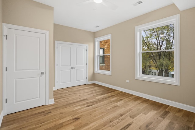 unfurnished bedroom featuring light wood-style floors, visible vents, baseboards, and a ceiling fan