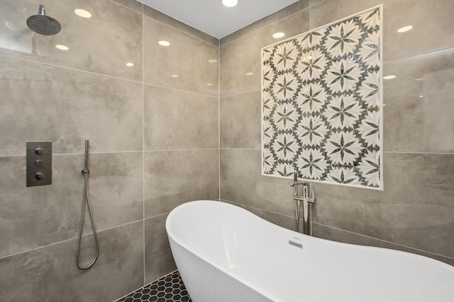 full bathroom featuring a freestanding bath, a tile shower, tile walls, and recessed lighting