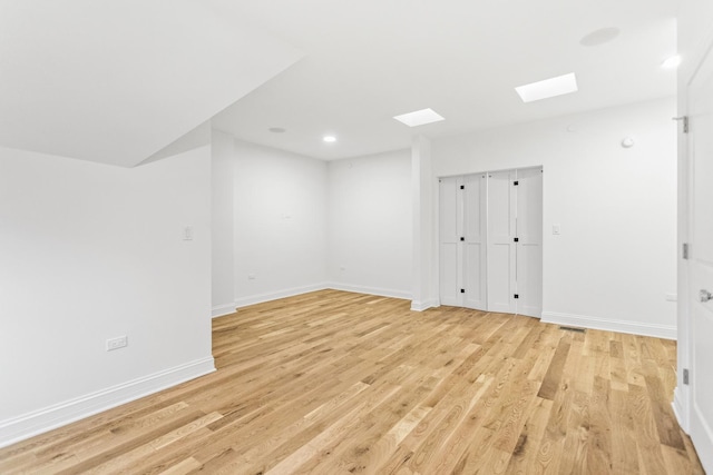 interior space featuring a skylight, light wood finished floors, recessed lighting, visible vents, and baseboards