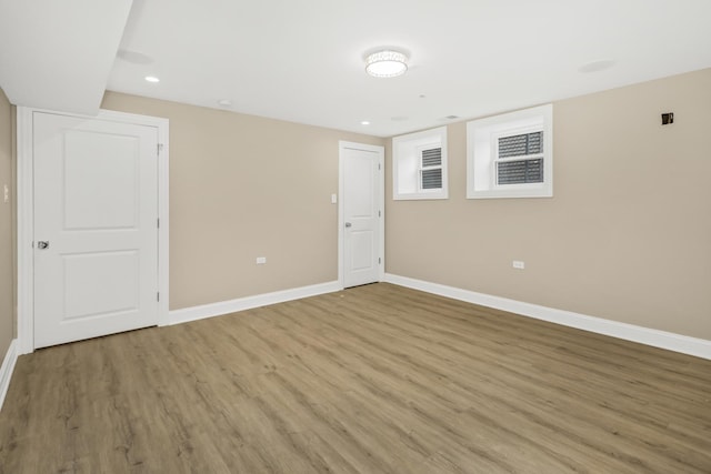 spare room featuring light wood-style floors, recessed lighting, and baseboards