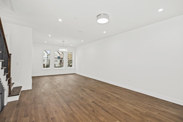 unfurnished living room featuring recessed lighting, dark wood-style flooring, stairway, and baseboards