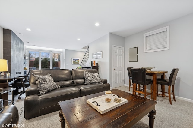 living room with recessed lighting, baseboards, light colored carpet, and stairs