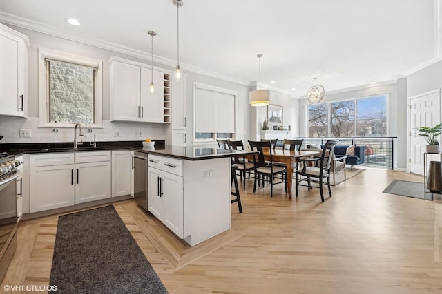 kitchen featuring ornamental molding, a sink, backsplash, white cabinetry, and dishwasher