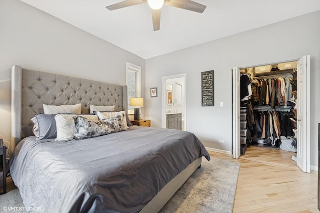 bedroom featuring ceiling fan, a spacious closet, light wood-style floors, a closet, and connected bathroom