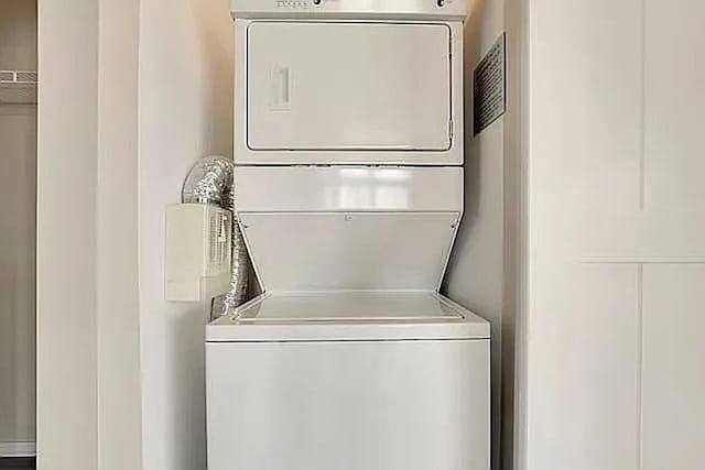 clothes washing area with laundry area and stacked washing maching and dryer