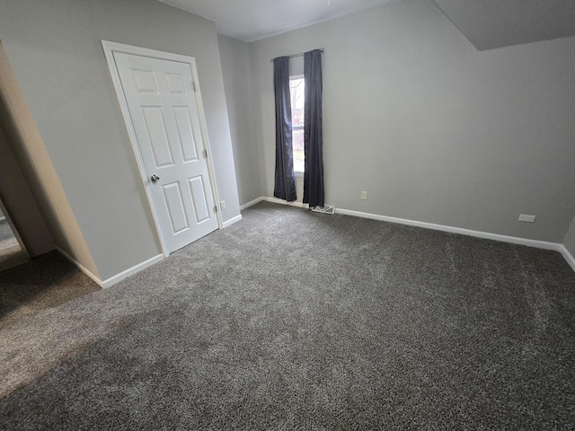 unfurnished bedroom with baseboards and dark carpet