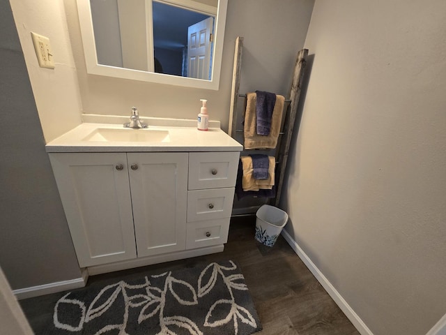 bathroom featuring vanity, baseboards, and wood finished floors