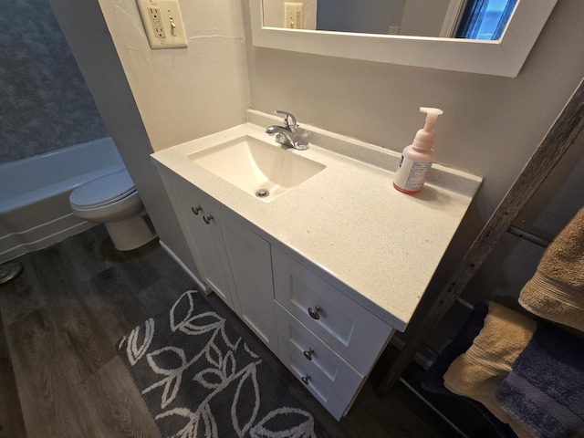 bathroom with a shower, vanity, toilet, and wood finished floors