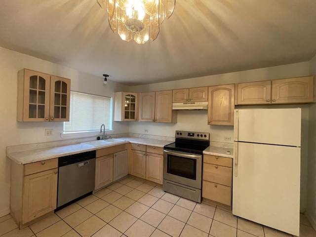 kitchen featuring under cabinet range hood, appliances with stainless steel finishes, a sink, and light brown cabinetry