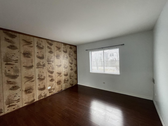 unfurnished room featuring dark wood finished floors and baseboards