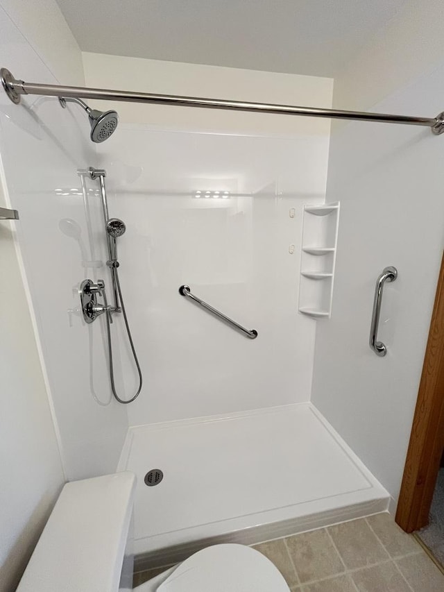 full bathroom featuring toilet and a shower stall