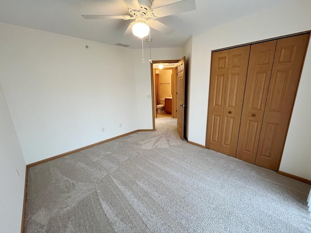 unfurnished bedroom with light carpet, visible vents, baseboards, and a closet