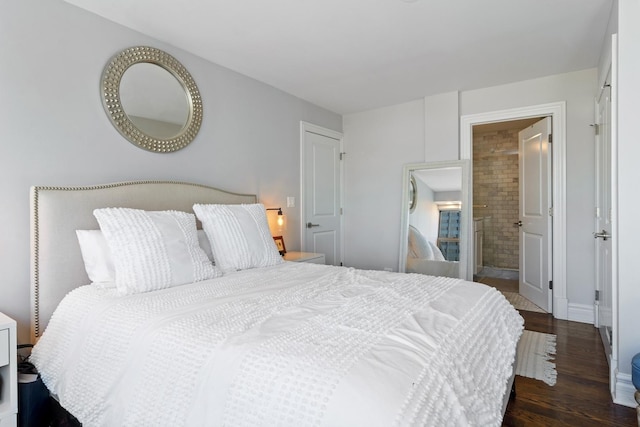 bedroom with ensuite bathroom, wood finished floors, and baseboards