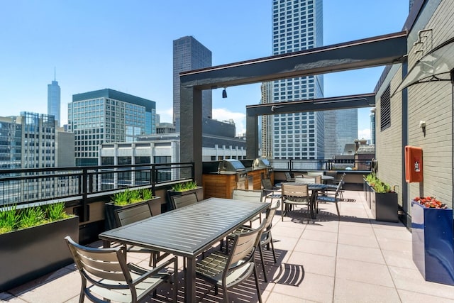 view of patio featuring outdoor dining space, a city view, an outdoor kitchen, and area for grilling