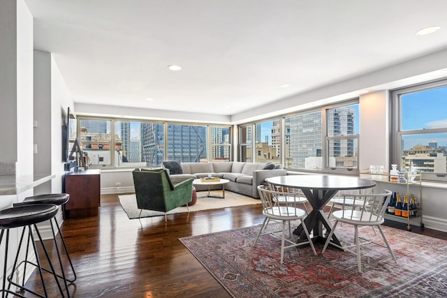 dining area featuring a view of city, recessed lighting, baseboards, and wood finished floors