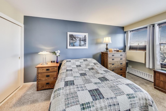 bedroom featuring a closet, baseboard heating, baseboards, and carpet floors