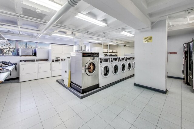 common laundry area featuring washer and dryer and light tile patterned floors