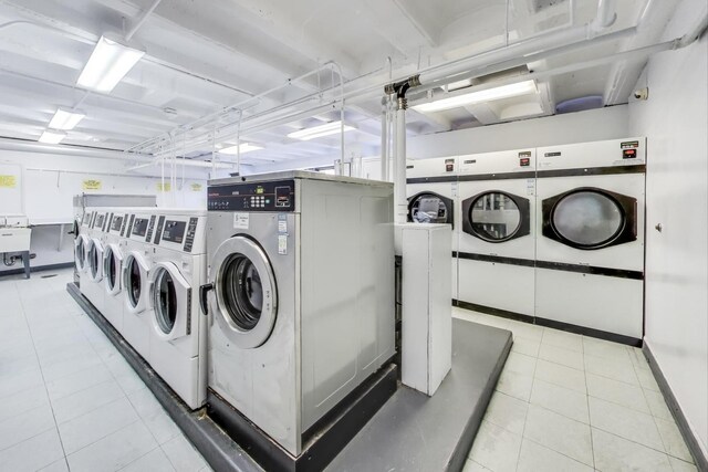 shared laundry area featuring tile patterned floors and washing machine and dryer