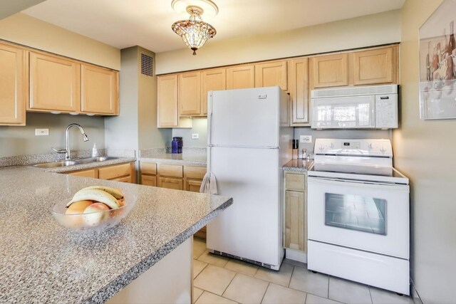 kitchen with white appliances, light brown cabinets, light tile patterned flooring, a sink, and light countertops