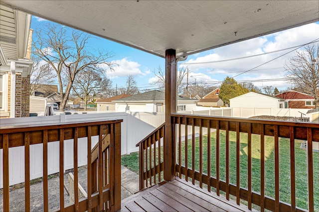 wooden deck featuring a lawn, a residential view, and a fenced backyard