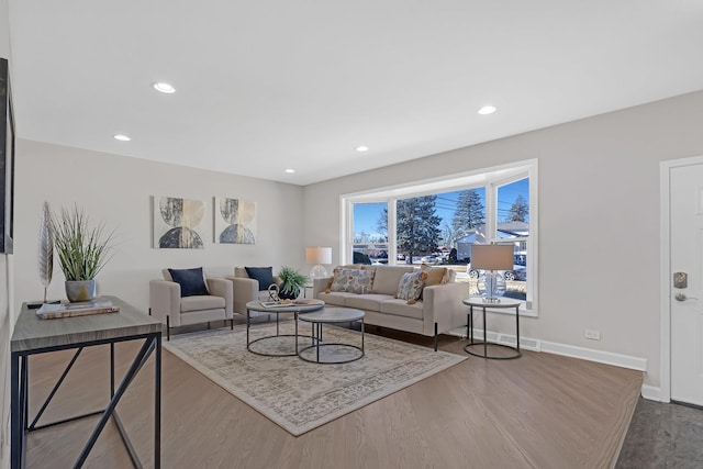 living area with baseboards, wood finished floors, and recessed lighting